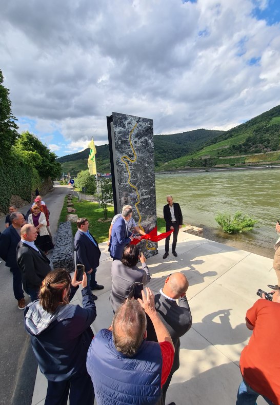 Innenminister Michael Ebling, Ortsbürgermeister Herbert Palmes und Volker Boch, Landrat des Rhein-Hunsrück-Kreises und Verbandsvorsteher des Zweckverbandes Welterbe Oberes Mittelrheintal, enthüllen die Lichtstele